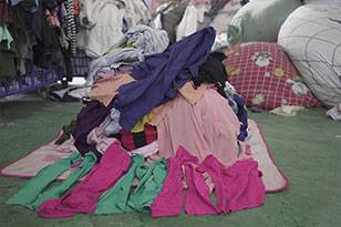 a pile of used clothing with bright, colorful shades