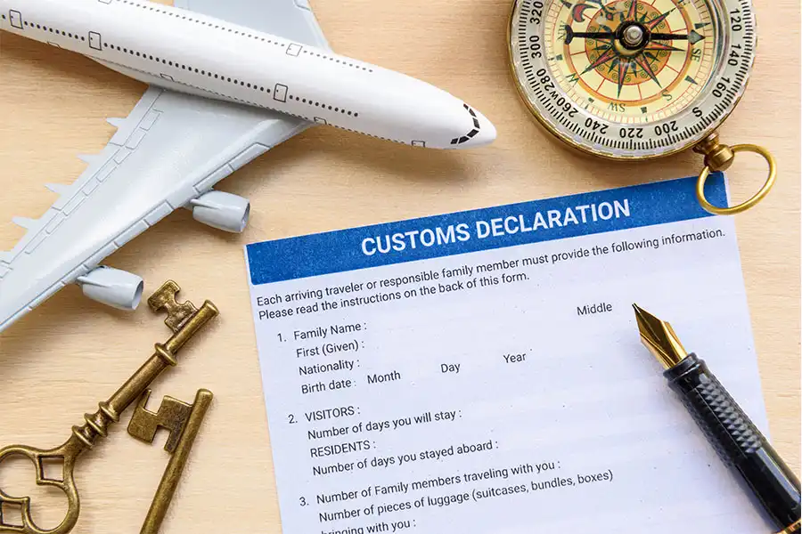 customs declaration form with a miniature airplane and compass