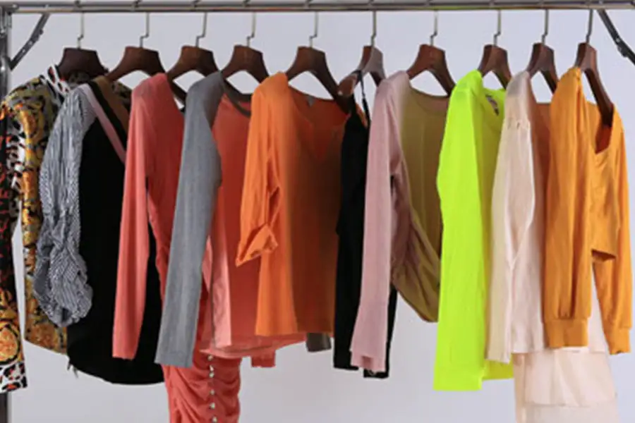 a rack of hanged colorful used clothing for women
