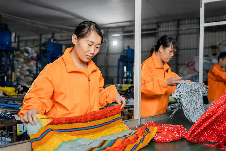 two sorters working on an order of used clothing