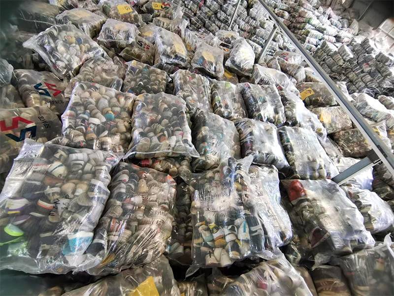 multiple bales of carefully sorted used branded shoes