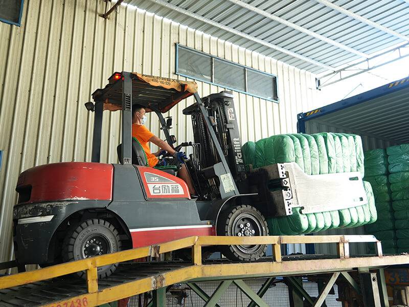 used clothing bales loaded on a container by forklift operator