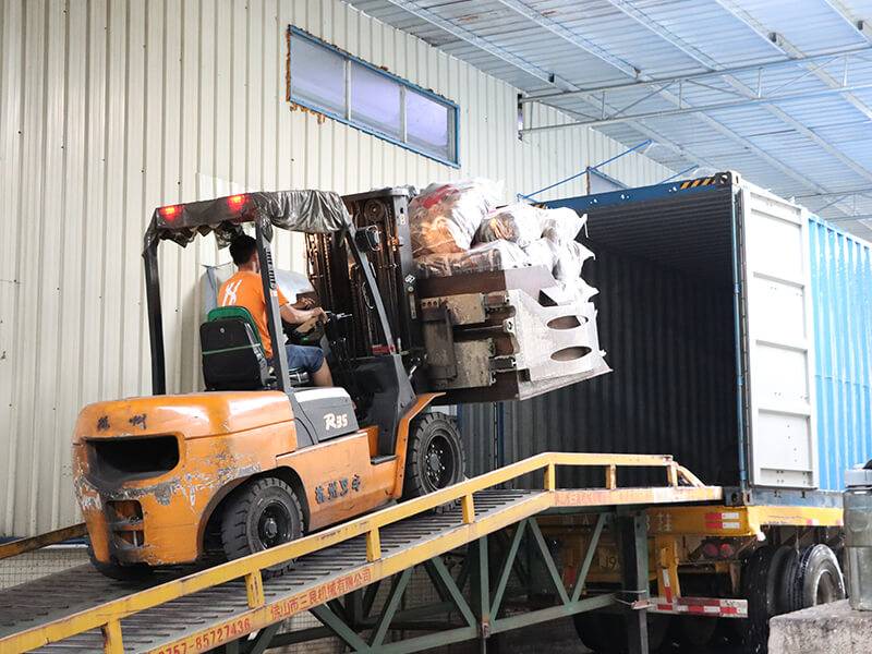 bales of used clothing carefully loaded on an empty cargo container