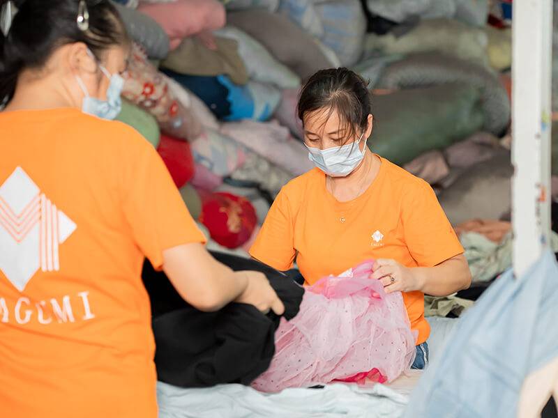 Sorting team carefully goes through pieces of used clothing 
