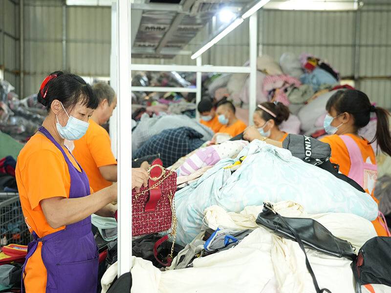 sorting team meticulously inspects each used clothing and bag to ensure quality