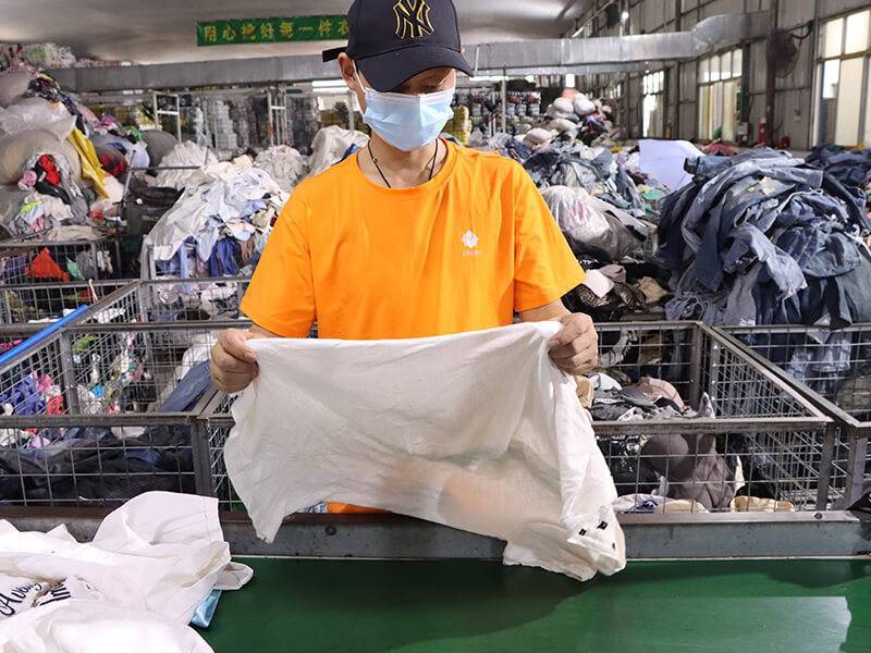 expert sorter inspecting a used white shirt